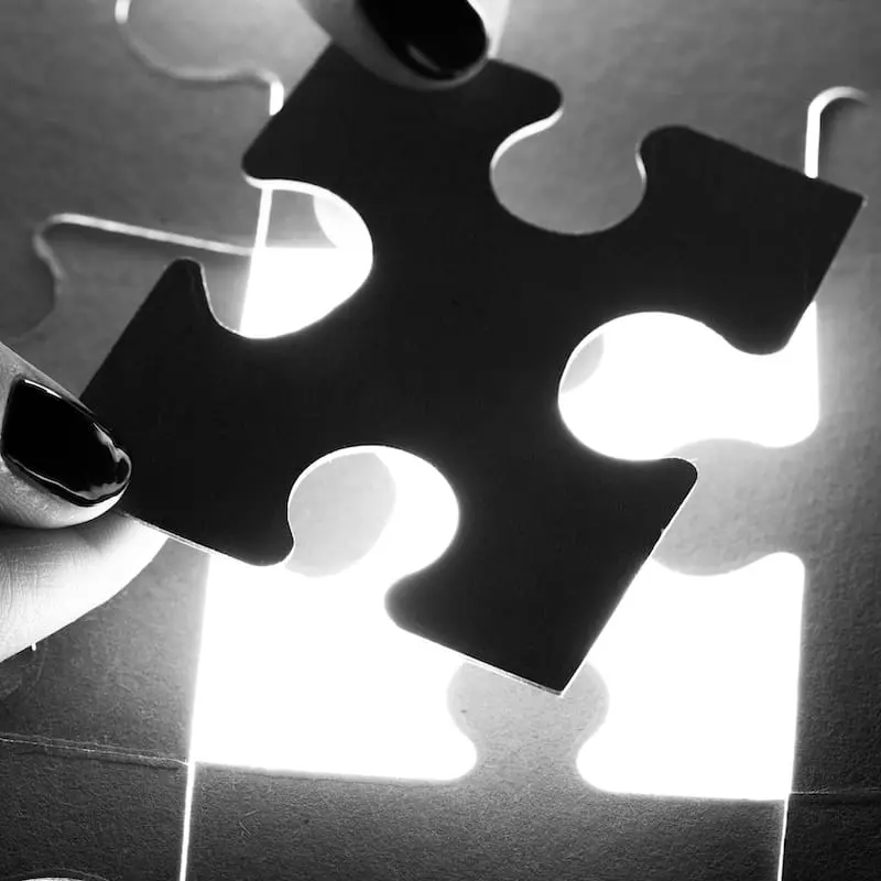 Puzzleteil wird in ein Gesamtbild eingefügt als Symbol für Transformation, Entwicklung, Potenzialentfaltung und nachhaltige Veränderung.