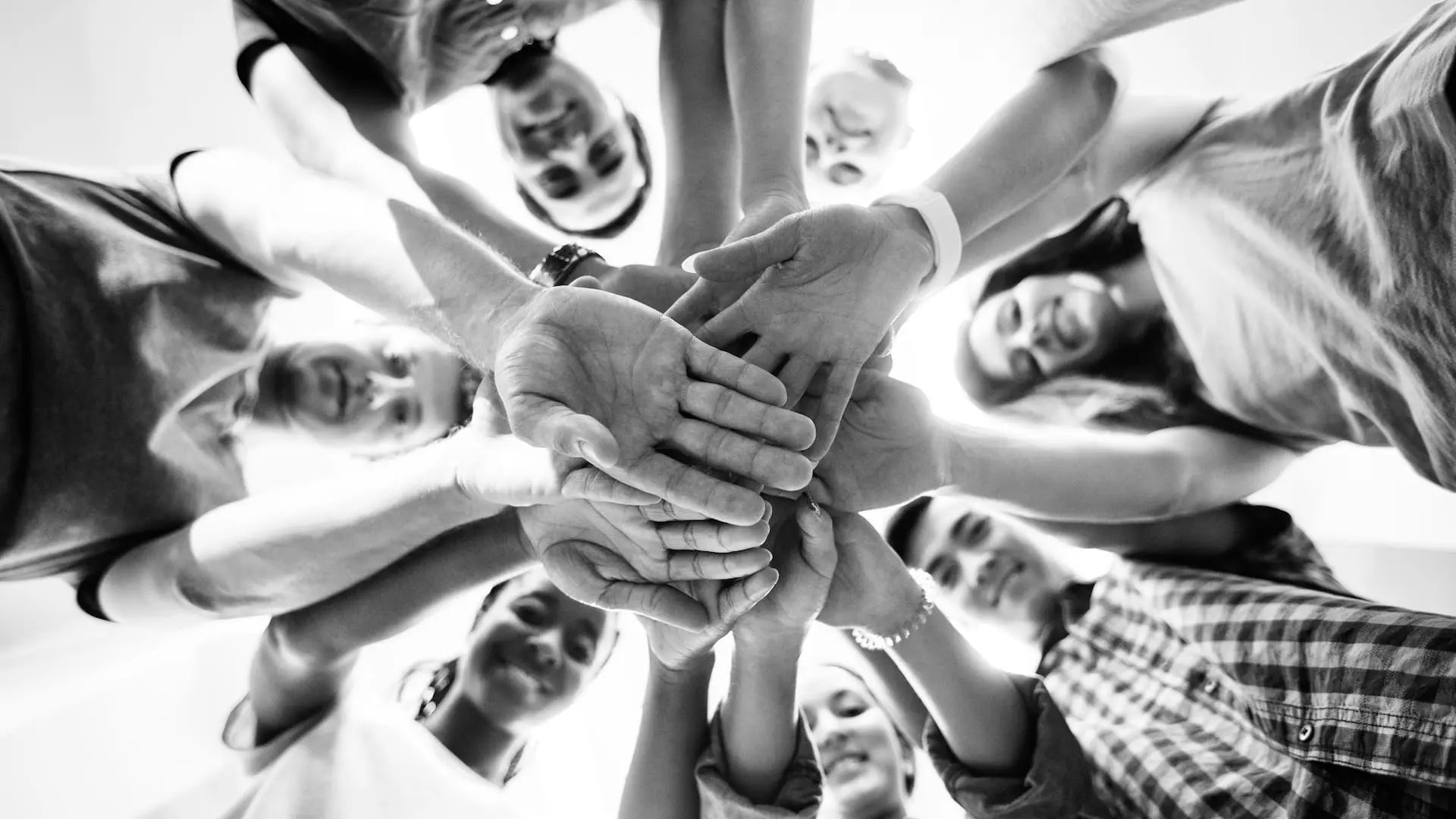 Reiss Motivation Profile® – Unterschiedliche Perspektiven verstehen Mehrere Menschen legen ihre Hände übereinander und symbolisieren Zusammenarbeit, unterschiedliche Perspektiven und gemeinsame Entscheidungsfindung.