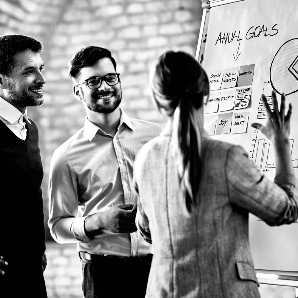 Unterstützungsprozesse | Zusammenarbeit durch gegenseitiges Verständnis Mehrere Personen arbeiten gemeinsam an einem Flipchart und tauschen unterschiedliche Sichtweisen zu einem Thema aus.