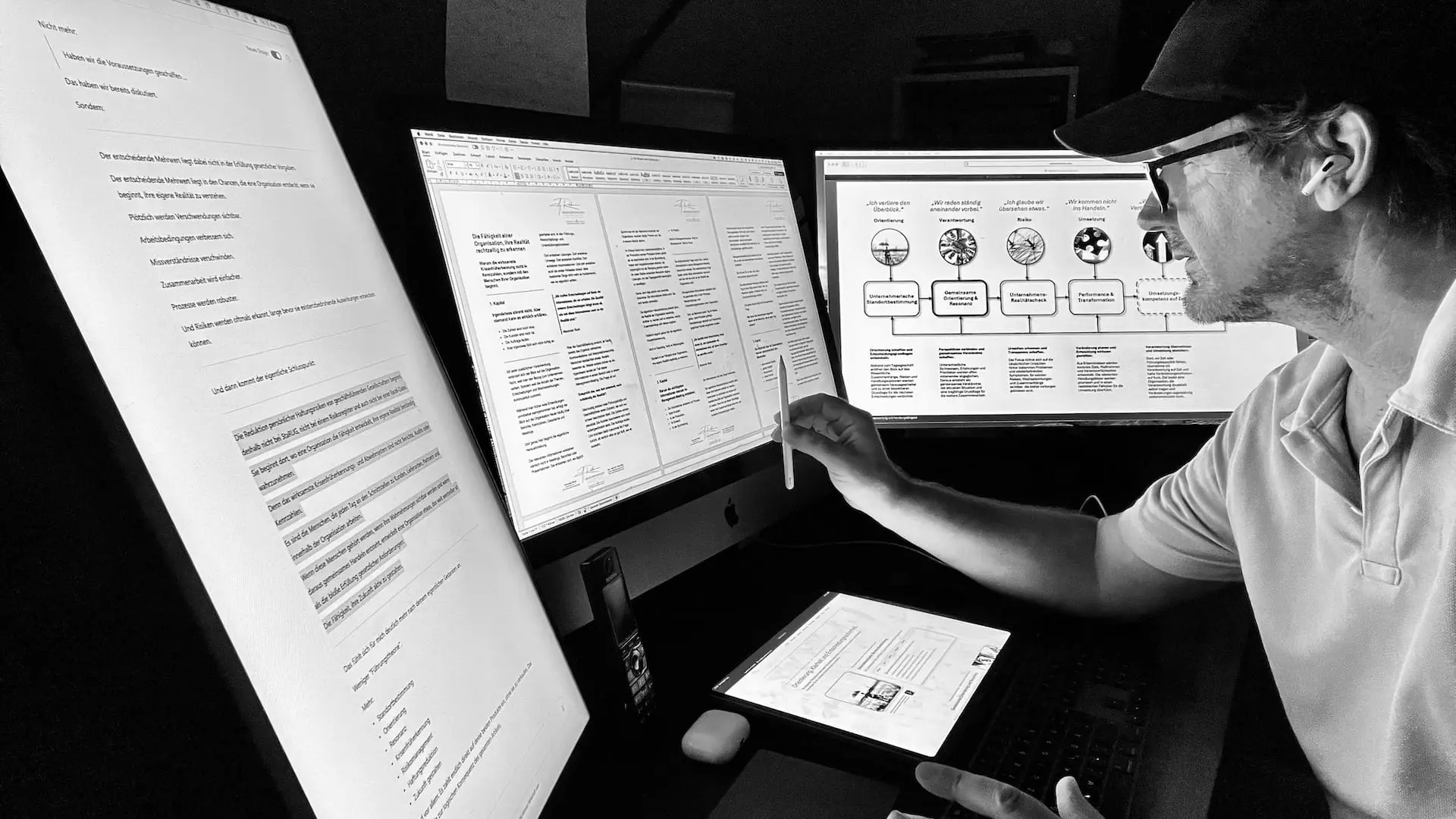 Arbeitsplatz mit mehreren Bildschirmen, auf denen Dokumente zur Krisenfrüherkennung, Organisationsentwicklung und Unternehmerischen Standortbestimmung bearbeitet werden.